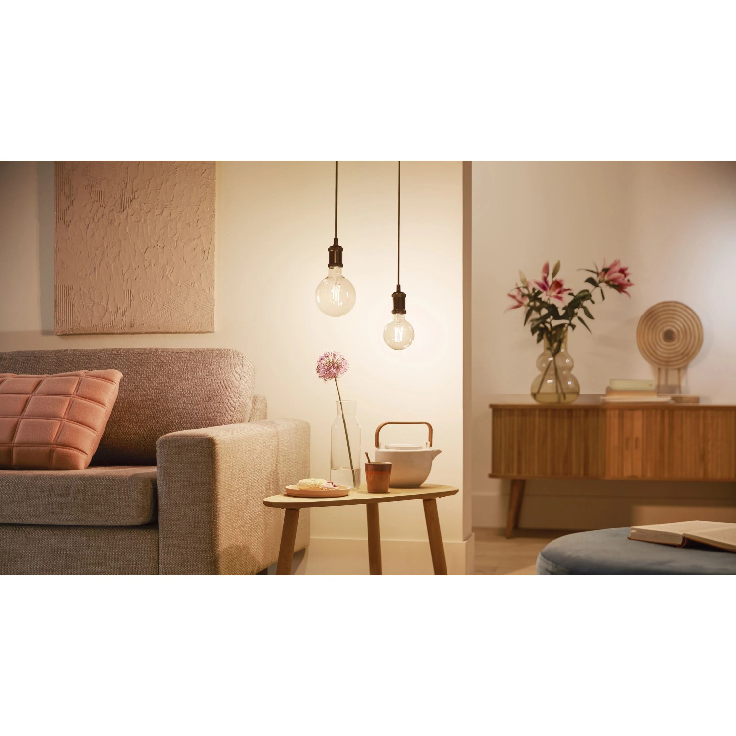 Philips Smart LED Filament Leuchtmittel, 7W E27 Globe, klares Glas, in Wohnraum-Szene.
