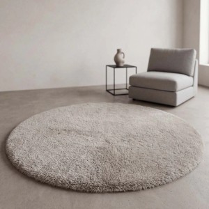 Runder, flauschiger Taupe-Teppich "Soft Cloud" im Wohnzimmer. Schafft eine gemütliche Atmosphäre.