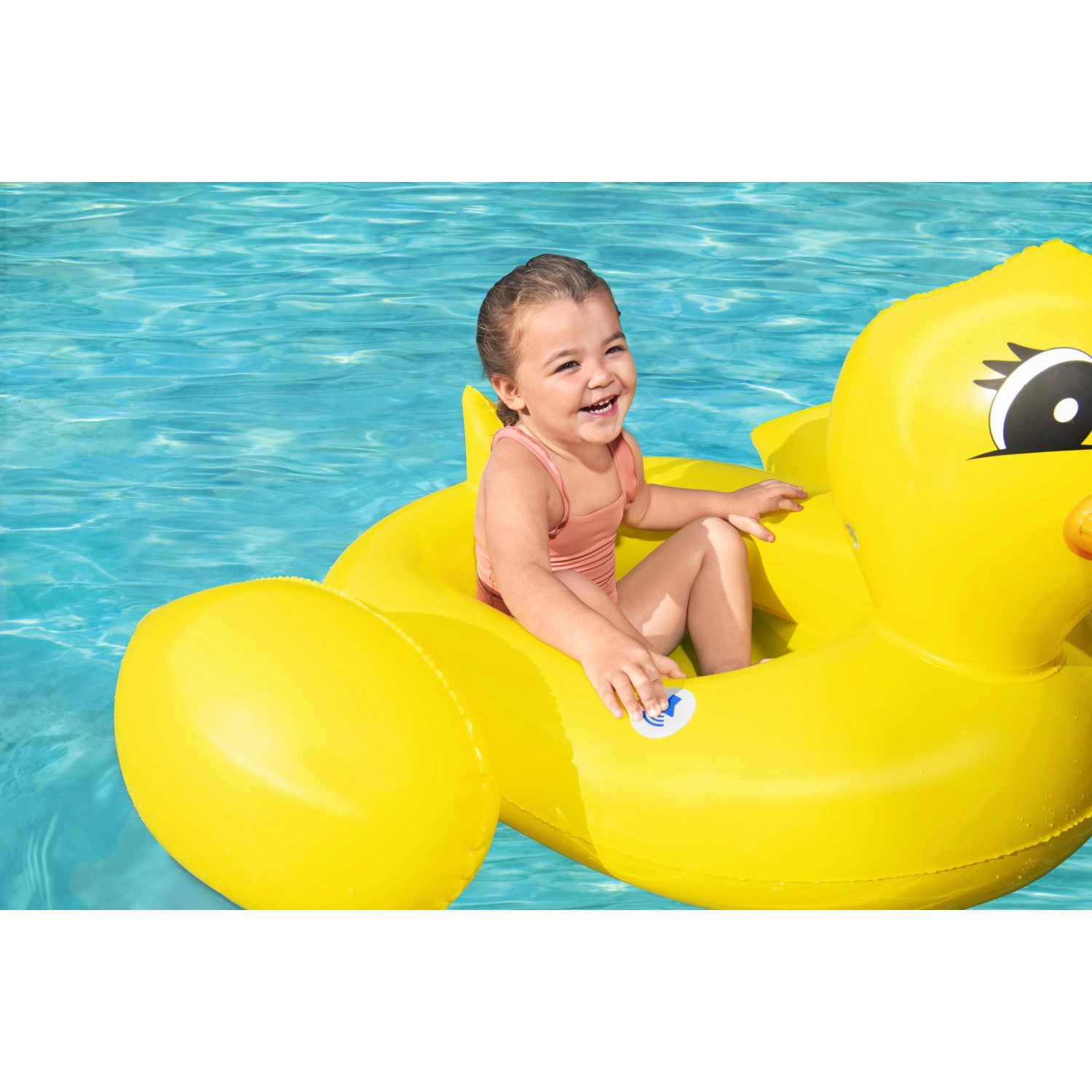 Fröhliches Kind im gelben Bestway Kinder-Schlauchboot Ente im Pool. Badespaß mit dem Schwimmtier!
