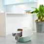 Rotho Katzentoilette Eco Bailey in Grün/Sand mit Katze beim Verlassen.