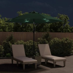 Grüner Ampelschirm mit LED-Beleuchtung und zwei Liegen im Garten.