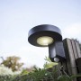 Anthrazitfarbene Lutec Solar-Außenwandleuchte Diso mit Bewegungsmelder an Holzzaun.