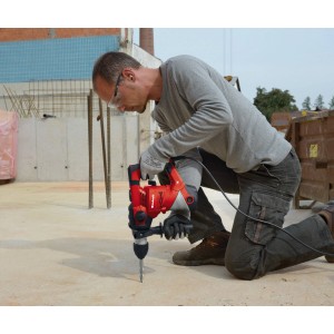 Mann bohrt mit rotem Einhell Bohrhammer TC-RH 900 im Koffer, mit Tiefenanschlag, in Beton.