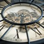 Wall-Art Wanduhr Vintage Zahnräder Schwarz-Gold. Detailansicht mit goldenen Zahnrädern, schwarzen Zeigern, römischen Ziffern.