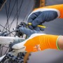 Hände mit LUX Arbeitshandschuhen Super Grip Gr. 9 reparieren ein Fahrrad.