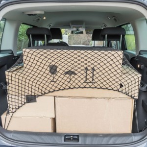 Schwarzes Kofferraumnetz aus Nylon sichert Kartons im Kofferraum eines Autos.