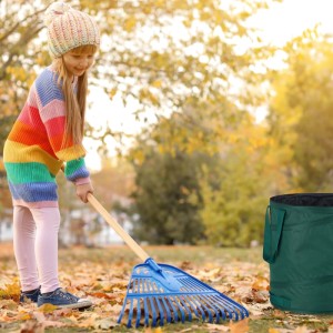 Grüner, selbstaufstellender Laubsack im Garten, während ein Kind Herbstlaub zusammenharkt. Ideal für Gartenabfälle.