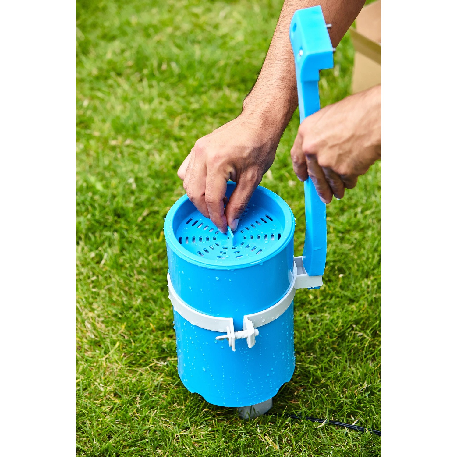 Blauer Summer Fun Einhängefilter Skimmy 2 beim Einsetzen in einen Pool, zur Reinigung der Wasseroberfläche.