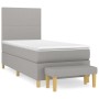 Helles Boxspringbett mit Matratze, hellgrauer Stoff, inklusive Bank. Komfortables Bett für erholsamen Schlaf.