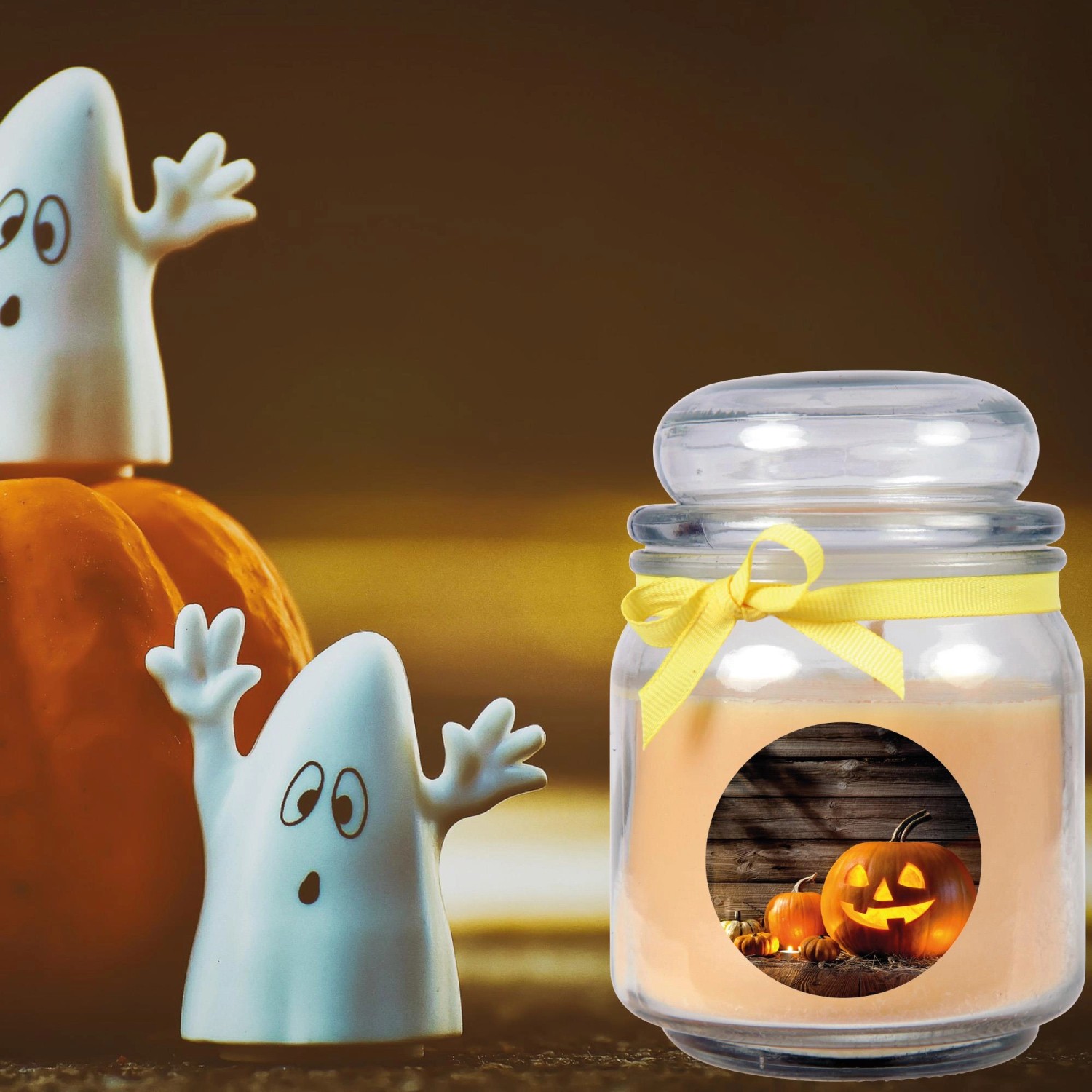 Halloween Duftkerze im Glas (Creme Bonbon) mit Kürbis- und Geisterdeko für stimmungsvolle Atmosphäre.