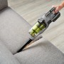 Ryobi Akku-Staubsauger RSVS18-0 One+ 18V in Aktion auf Sofa. Handstaubsauger für Möbelreinigung.