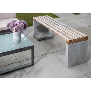 Grauer L-Stein als Basis für eine Holzbank im Garten. Einfassung und Mauersystem.