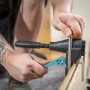 Mann fixiert Türfutter mit schwarzer wolfcraft Richtzwinge und türkisfarbenem Hebel.