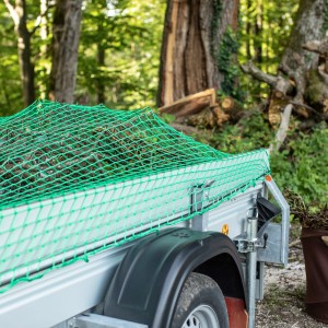 Grünes Windhager Ladungssicherungsnetz über Anhänger mit Ladung, Maschenweite 4,5x4,5 cm.