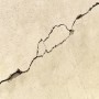 Riss in beiger Wand, reparierbar mit Fischer Reparaturspachtel (3er-Pack).
