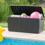Geöffnete Keter Aufbewahrungsbox Capri 305 l in Rattanoptik am Pool, gefüllt mit Spielzeug.