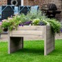 Graue Dobar Mährobotergarage mit Pflanzkasten, bepflanzt mit bunten Blumen.