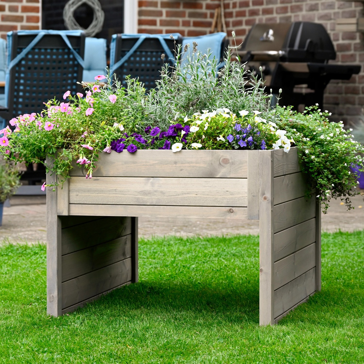 Graue Dobar Mährobotergarage mit Pflanzkasten, bepflanzt mit bunten Blumen.