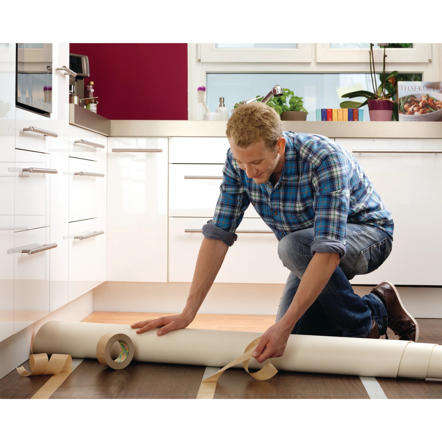 Mann verlegt Bodenbelag mit Tesa doppelseitigem Klebeband Eco Fixation. Klebeband und Bodenbelag im Fokus.