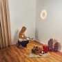 Frau baut grüne Kunsttanne Nagano (150 cm) auf. Weihnachtsdeko im Raum.