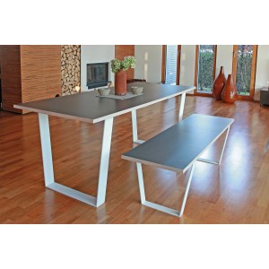 Tisch mit weißem Tischuntergestell in V-Form und passender Bank im Wohnraum.