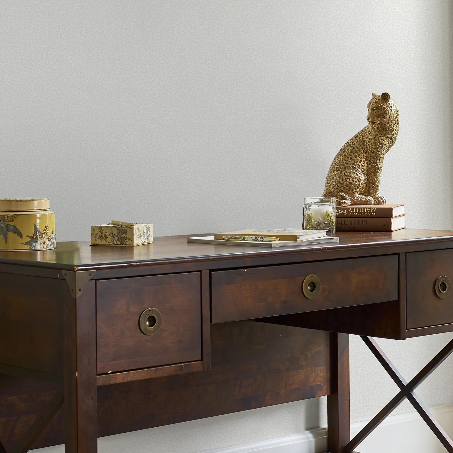 Laura Ashley Vliestapete Little Vines Paintable an Wand über dunklem Holzschreibtisch.