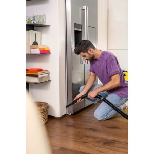 Mann nutzt Kärcher Fugendüse zum Saugen einer Fuge. Flexibles Zubehör für Nass-/Trockensauger.