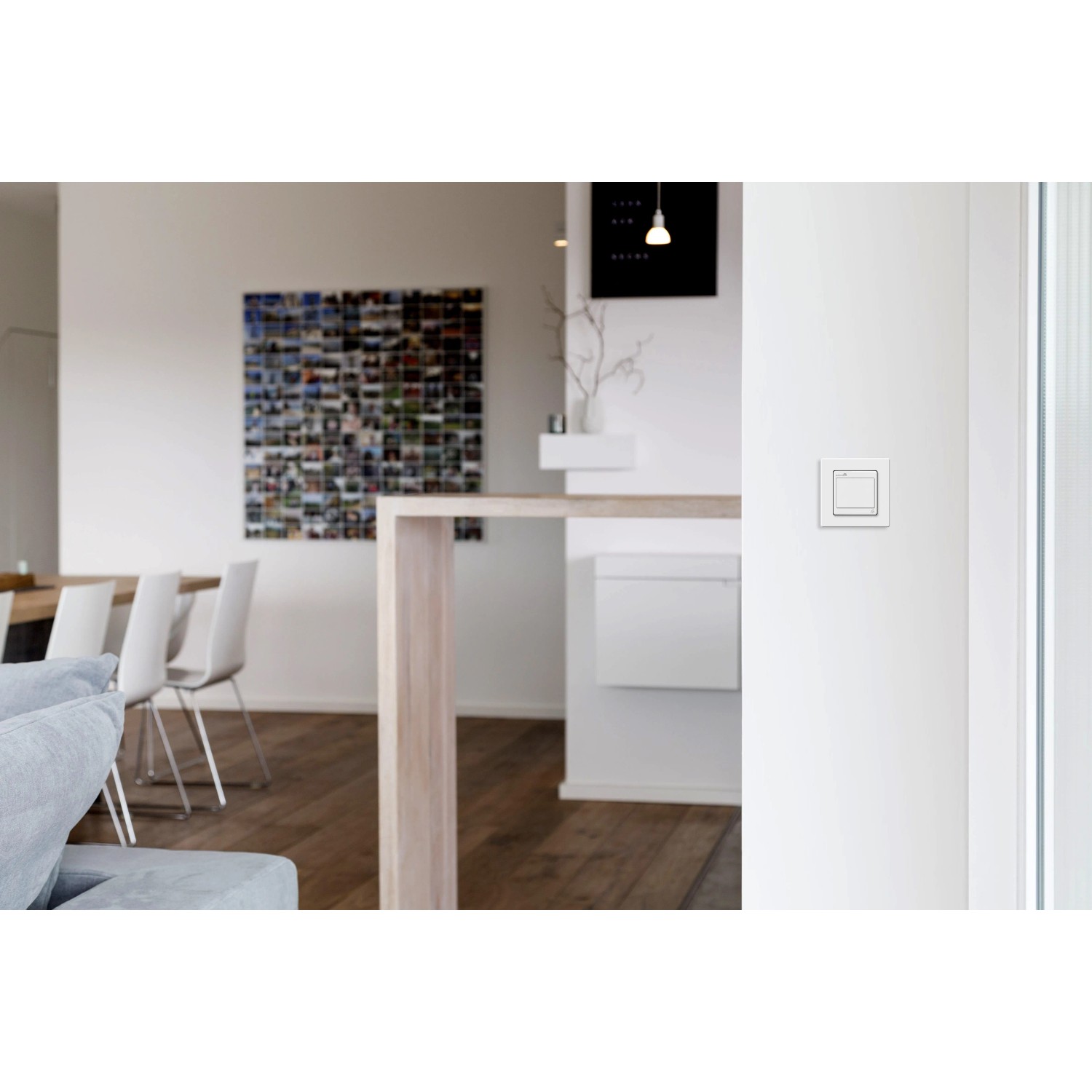 Weißer Funk-Lichtschalter Unterputz an Wand im Wohnraum. Hausfunksteuerung für smarte Beleuchtung.
