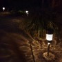 Zehn beleuchtete LED Solar Wegleuchten aus Edelstahl mit Erdspieß im Garten bei Nacht, erzeugen warmweißes Licht und Muster.
