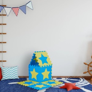 Blaue und gelbe Relaxdays Puzzlematte mit Sternen aus EVA-Schaumstoff, als Haus im Kinderzimmer auf blauem Teppich.