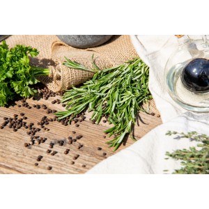 Frischer Rosmarin 'Riviera' und Kräuter auf Holztisch, ideal zum Kochen.