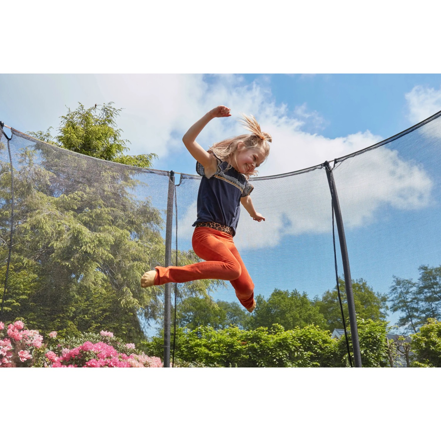Mädchen springt auf pinkem Salta Comfort Edition Bodentrampolin (214x153cm) mit Sicherheitsnetz.