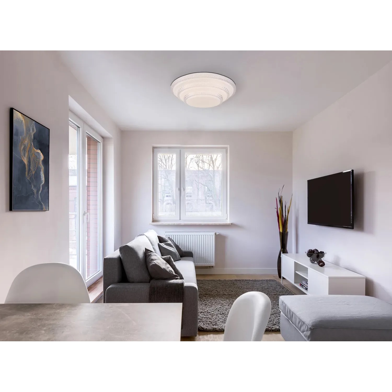 Weiße Globo LED-Deckenleuchte Magnifique, Ø 49,5 cm, im Wohnraum mit Sofa und TV.