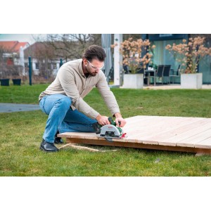 Mann sägt Holz mit Bosch Akku-Handkreissäge EasyCirc 18V-48. Handkreissäge für präzise Holzschnitte.