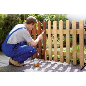 Mann streicht Zaun auf LUX Abdeckvlies. Schutzvlies 1 m x 25 m schützt vor Farbspritzern.