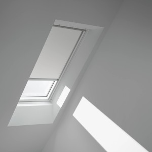 Velux Verdunkelungsrollo DML CK02, weiß-alu, am Dachfenster mit Sonneneinstrahlung.