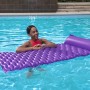 Frau entspannt auf lila Bestway Luftmatratze Float'n Roll (213x86cm) im Pool.