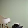 PROFHOME Uni Tapete in Matt Grün an Wand, mit Stuhl und Boxen im Raum.
