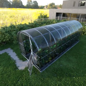 Großes Klasika Arch Gewächshaus 18m² mit Polycarbonatabdeckung und geöffneter Tür im Garten.