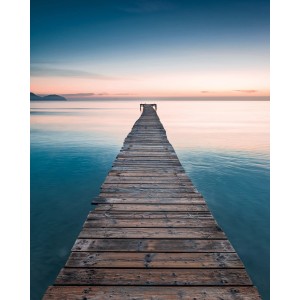 Komar Fototapete Vlies Morning Breeze: Steg ins ruhige, rosa-blaue Meer bei Sonnenaufgang.