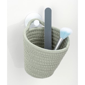 Wenko Aufbewahrungskorb Soria lindgrün mit Kosmetikartikeln, hängend an weißer Wand.