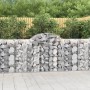 Zwei Gabionen mit Hochbogen, gefüllt mit Steinen, als dekorativer Sichtschutz im Garten.