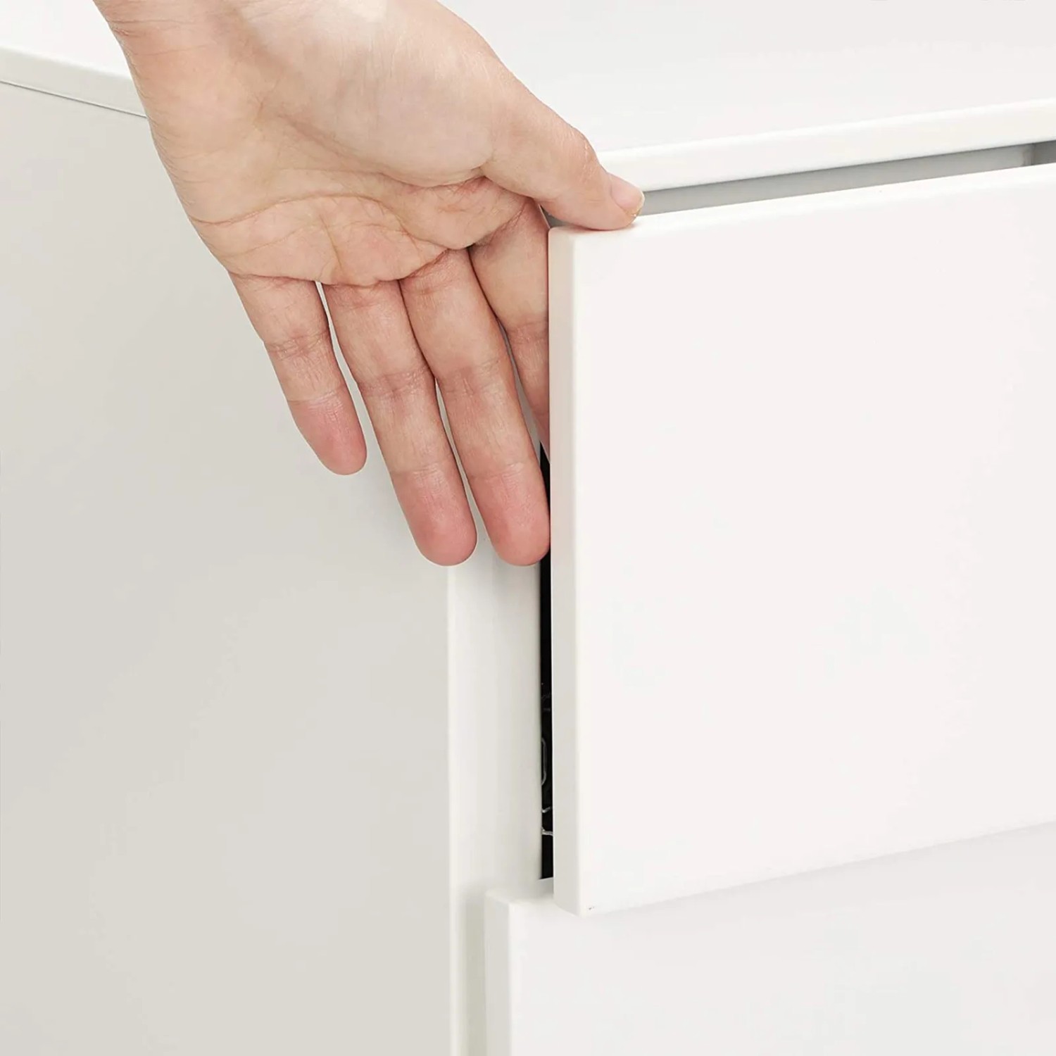 Detailaufnahme: Hand öffnet Schublade des weißen Songmics Aktenschranks.