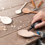 Dremel Stylo+ Multifunktionswerkzeug beim Bearbeiten eines Holzlöffels.