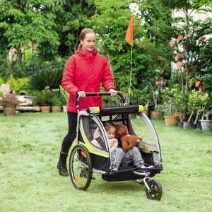HOMCOM 2-in-1 Kinderfahrradanhänger mit Kind und Teddy im Garten.