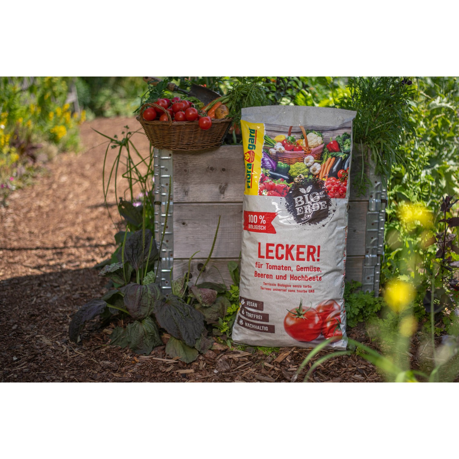 Floragard Bio-Tomaten-Gemüseerde Lecker 40L Sack vor Gartenbeet mit Gemüse.