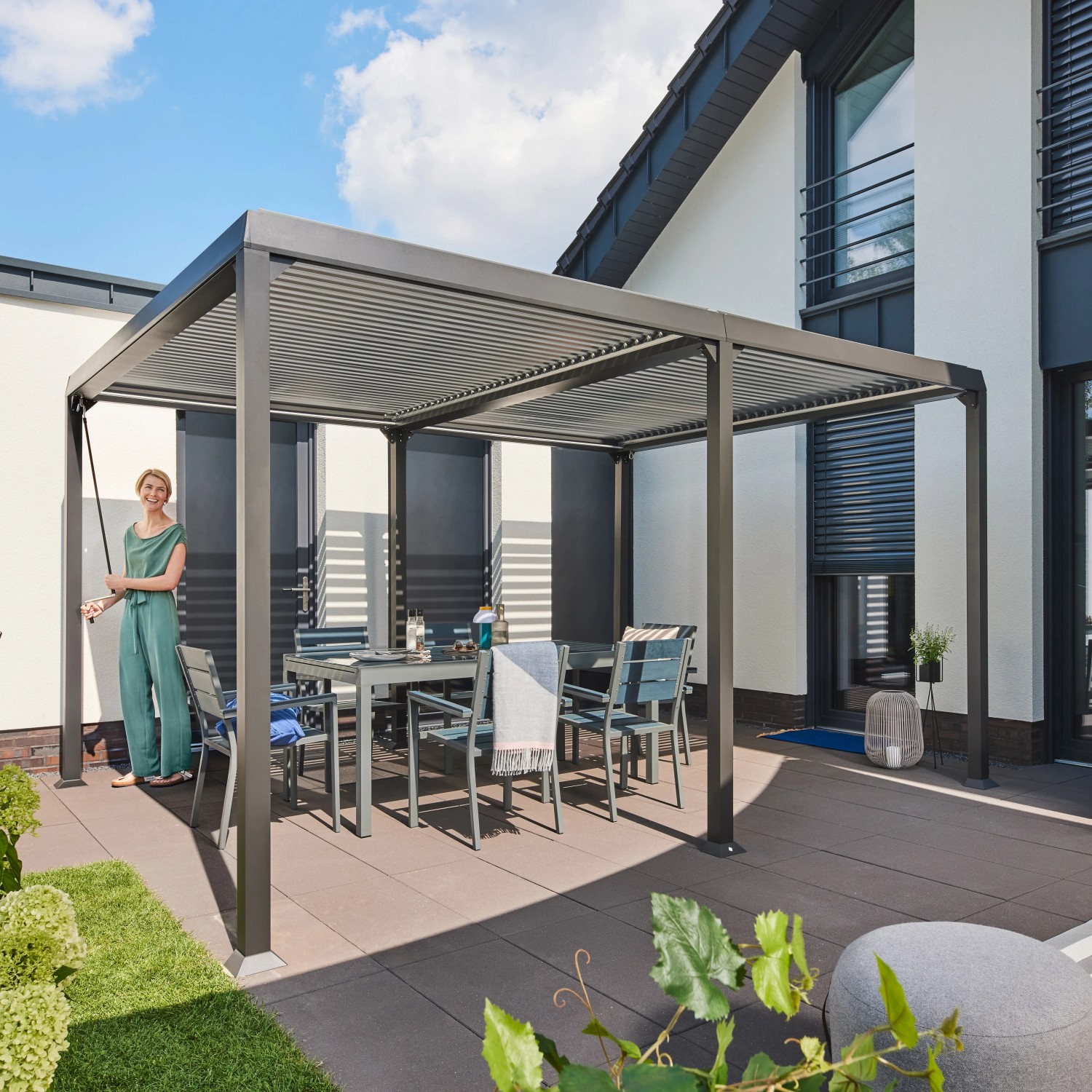 Home Deluxe Pavillon Cannes mit Lamellendach und Gartenmöbeln auf Terrasse.