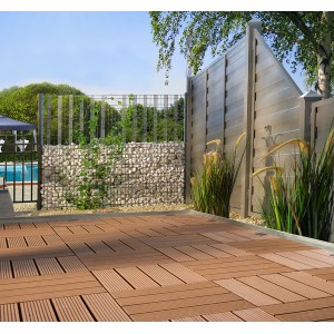 Braune Florco WPC Klickfliesen (6 Stk.) auf Terrasse mit Gabionenwand und Zaun im Hintergrund.