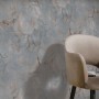 Erismann Vliestapete Melissa Venora Anthrazit mit Marmor-Effekt hinter Sessel.
