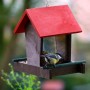 Dobar Vogelhaus mit rotem Dach und Meise am Futterspender.